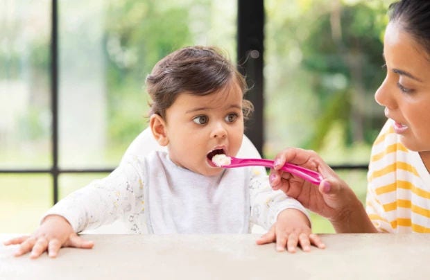 Baby eating broccoli